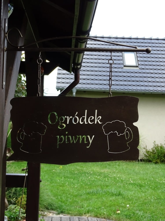 Metalowa tabliczka z napisem "Ogródek piwny" w kolorze złotej rdzy do zawieszenia - wyjątkowy element upiększający